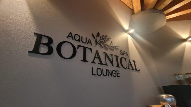 Logo aus schwarzem Acryl Logo und Schriftzug aus schwarzem Acryl auf der Wand verklebt